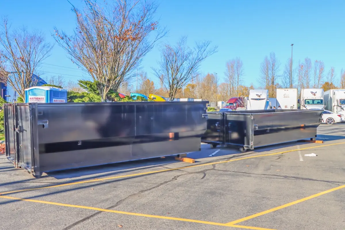 Professional dumpster rental service with roll-off container on residential driveway in Portage